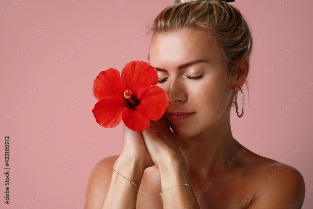 Close-up of caucasian young woman with red flower. Healthy and glossy skin. Close-up of caucasian young woman with red flower. Healthy and glossy skin.