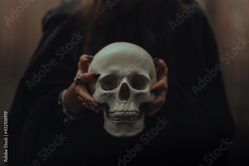 skull of a dead man in the hands of a witch witch