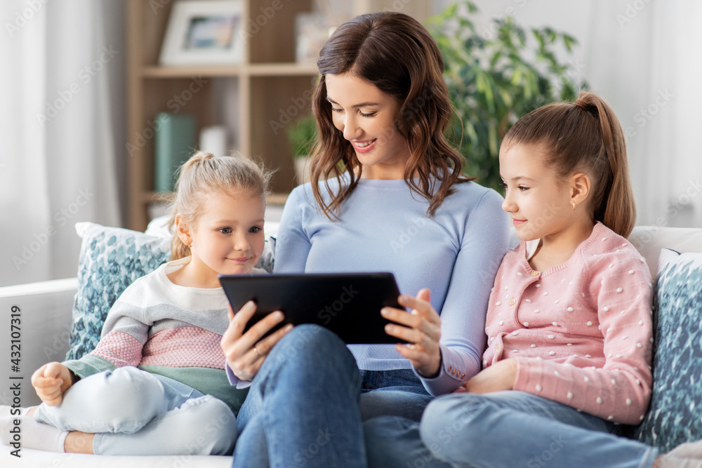 people, family and technology concept - happy mother and two daughters with tablet pc computer at home people, family and technology concept - happy mother and two daughters with tablet pc computer at home