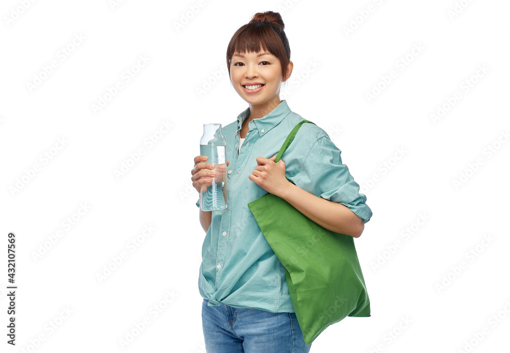 sustainability, eco living and people concept - portrait of happy smiling young asian woman with green reusable canvas bag for food shopping and glass bottle of water over white background sustainability, eco living and people concept - portrait of happy smiling young asian woman with green reusable canvas bag for food shopping and glass bottle of water over white background