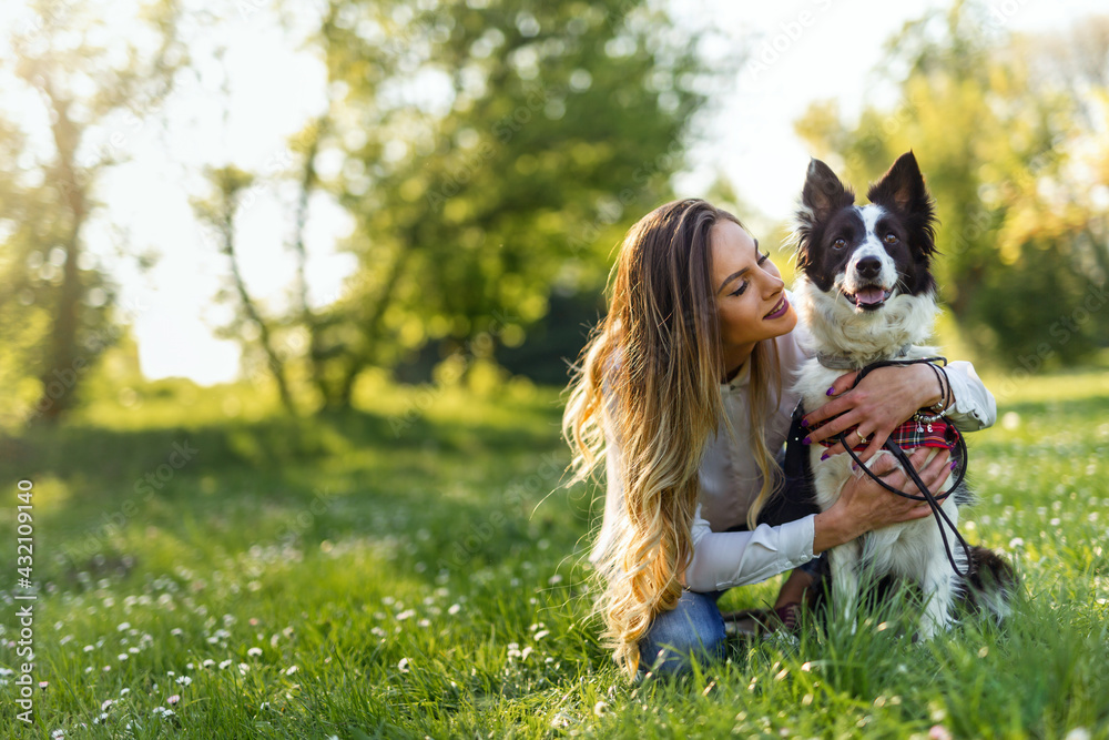 Happy young woman playing with her dog in park Happy young woman playing with her dog in park