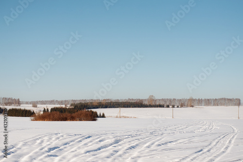 Tracks of vehicles on a field covered with snow.