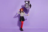 Photo of pretty cute young lady dressed striped clothes arm cap holding silver heart balloons isolated purple color background