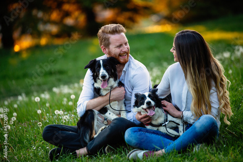 Young couple in love walking and enjoy time in park with dogs