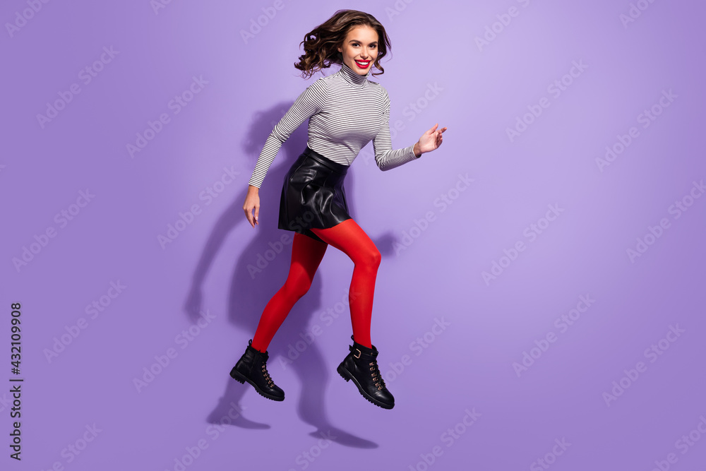 Full size profile side photo of young cheerful girl happy positive smile go walk run hurry jump isolated over purple color background Full size profile side photo of young cheerful girl happy positive smile go walk run hurry jump isolated over purple color background