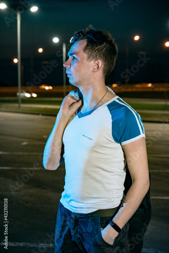 A young man in the parking lot at night amid the lanterns photo