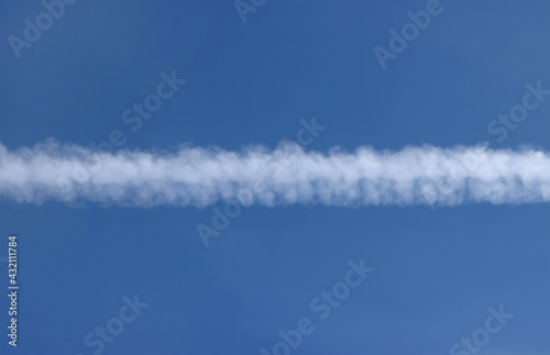 Airplane trail in the blue sky.