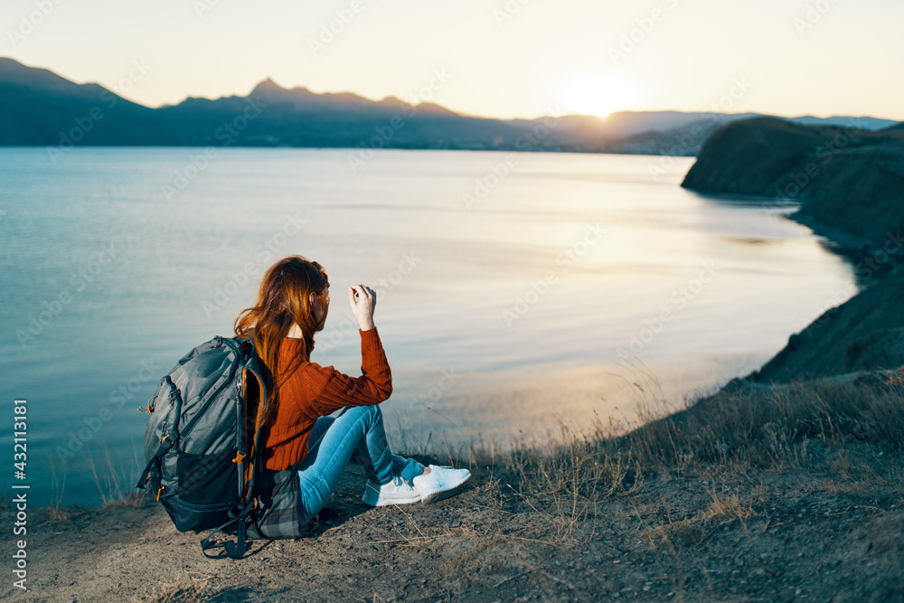 woman on vacation resting in the mountains near the sea at sunset