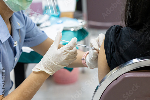 Close up doctor, nurse holding syringe making covid-19 vaccination injection dose in shoulder patient. Corona virus treatment side effect, close up view. Flu Vaccination Injection on Arm.