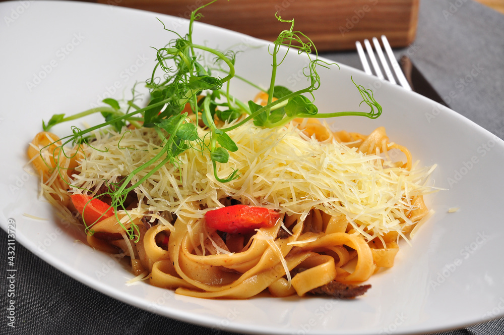 pasta with veal, vegetables and Parmesan on a white plate pasta with veal, vegetables and Parmesan on a white plate