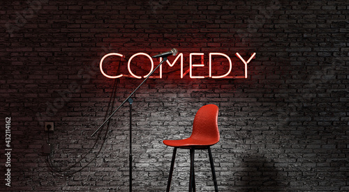 stage lit by a spotlight and a red neon lamp with the word COMEDY photo