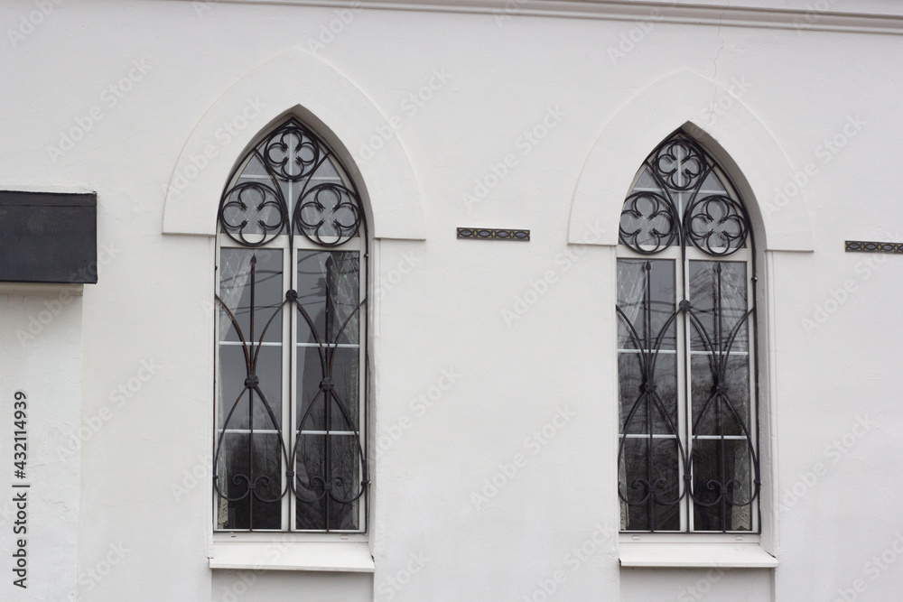 Windows in the form of arches, with wrought-iron bars.