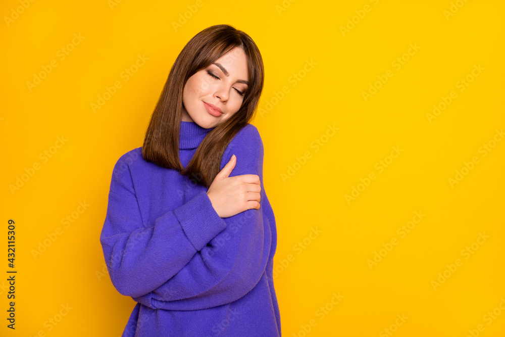 Photo of shiny dreamy young woman wear purple pullover hugging herself closed eyes isolated yellow color background Photo of shiny dreamy young woman wear purple pullover hugging herself closed eyes isolated yellow color background