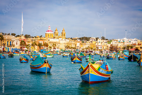 malta - marsaxlockk port filled with typical boats called luzzu