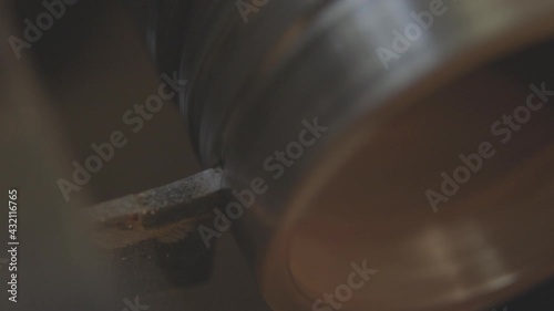 A lathe cuts metal, close-up. Old lathe with an iron billet, working process.