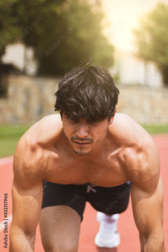 Obraz premium a strong boy doing sports on a running track