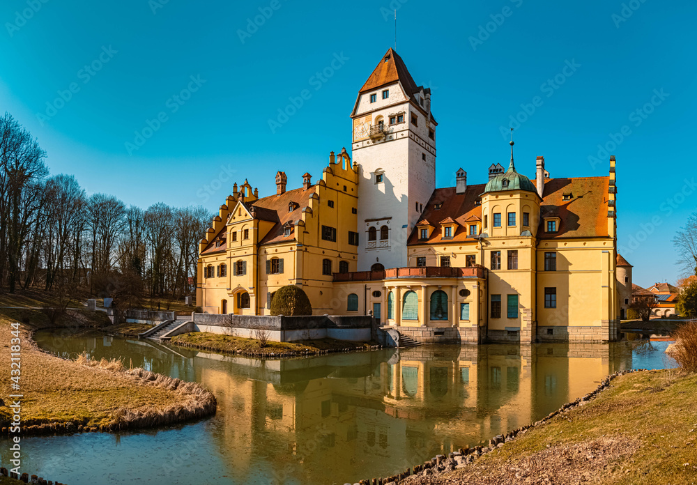High resolution stitched panorama of a beautiful winter view on a sunny day with a water castle and reflections at Schoenau, Bavaria, Germany