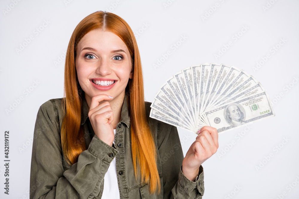 Photo of optimistic nice orange hair lady hold money wear grey shirt isolated on white color background Photo of optimistic nice orange hair lady hold money wear grey shirt isolated on white color background