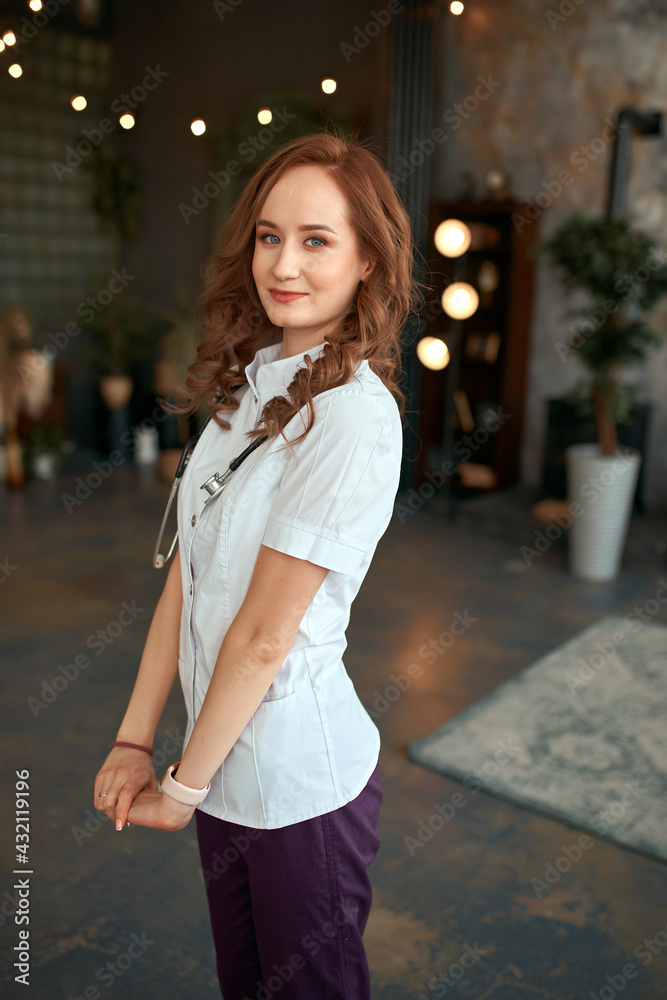 Fototapeta premium The girl in a white robe. Beautiful girl doctor in the office.