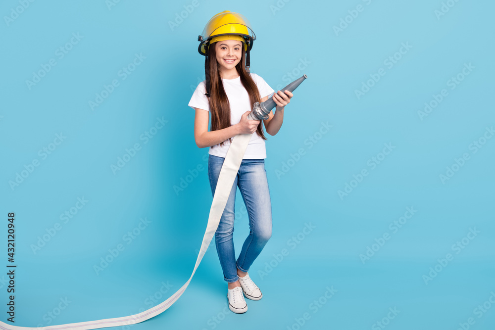 Full length body size view of attractive trendy cheerful girl fighting fire with water isolated over vivid blue color background Full length body size view of attractive trendy cheerful girl fighting fire with water isolated over vivid blue color background