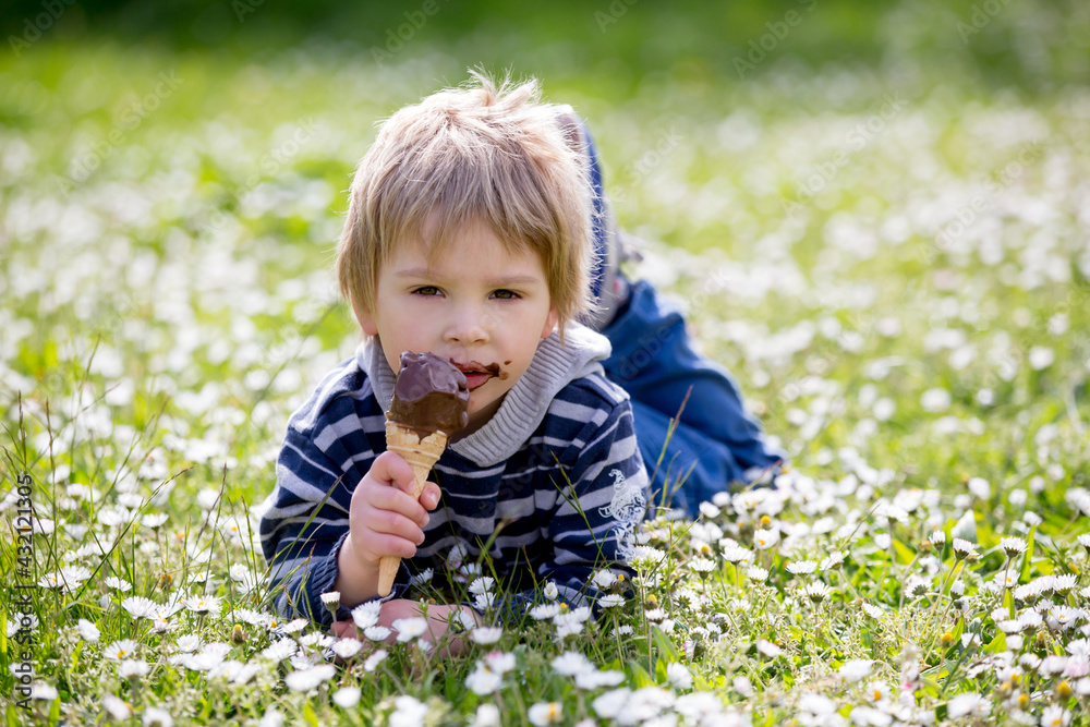 Cute blond child, boy, eating ice cream in the park Cute blond child, boy, eating ice cream in the park