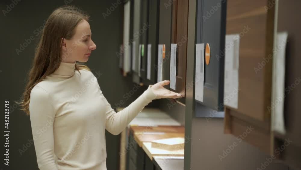 Young woman in shop choosing material for facades for kitchen furniture. Young woman in shop choosing material for facades for kitchen furniture.