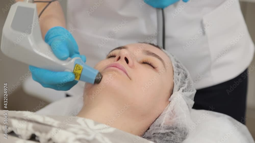 Woman beautician doing laser facial rejuvenation. Woman beautician doing laser facial rejuvenation.