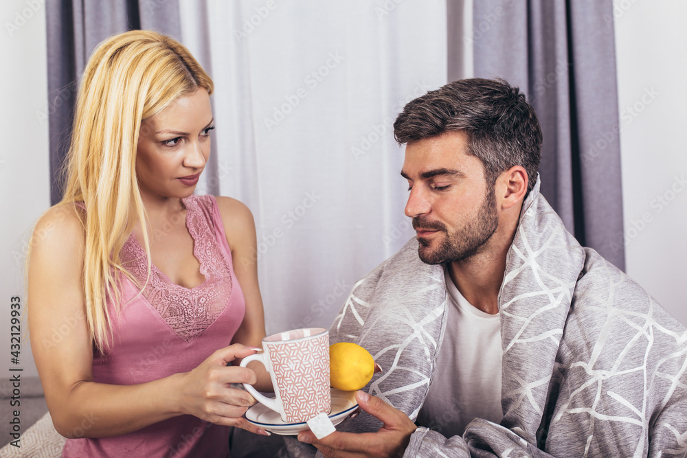 Woman taking care of her sick boyfriend lying in the bed. Woman taking care of her sick boyfriend lying in the bed.