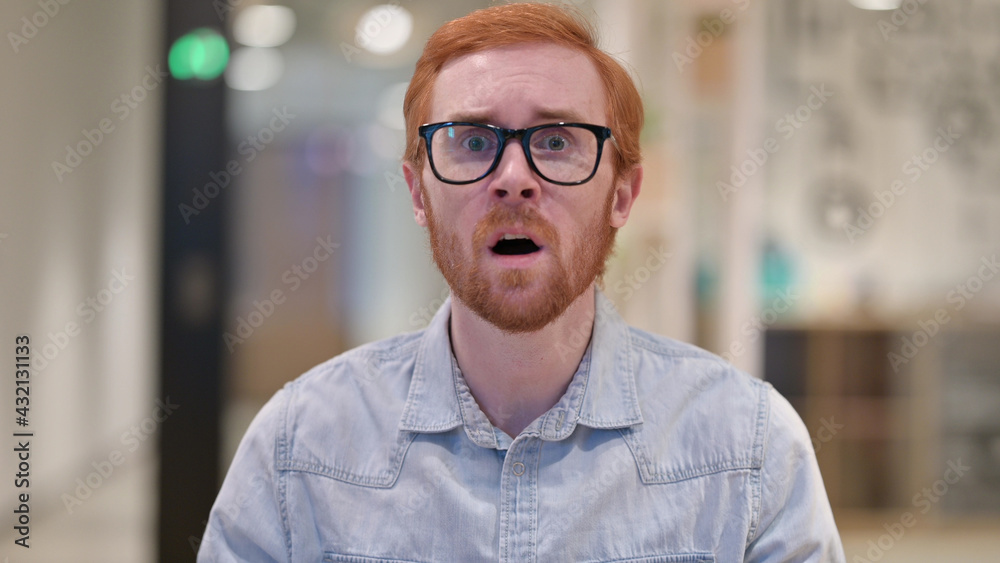 Fototapeta premium Young Redhead Man Shocked by Loss, Failure