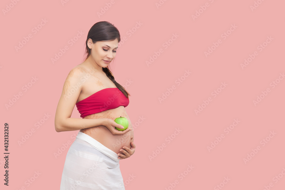 young pregnant woman holds a green apple young pregnant woman holds a green apple