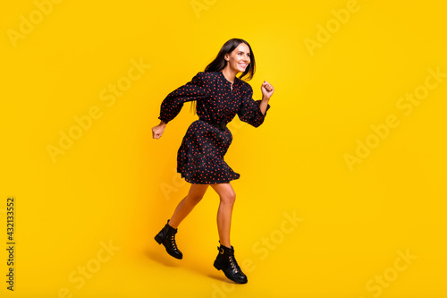 Full length body size view of attractive cheerful girl jumping running motivation isolated over bright yellow color background