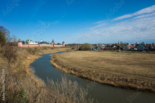 Suzdal view with river Kamenka  Saint Euthymius monastery red wall with towers  residential area and central Russia nature in spring in middle april  Golden Ring of Russia