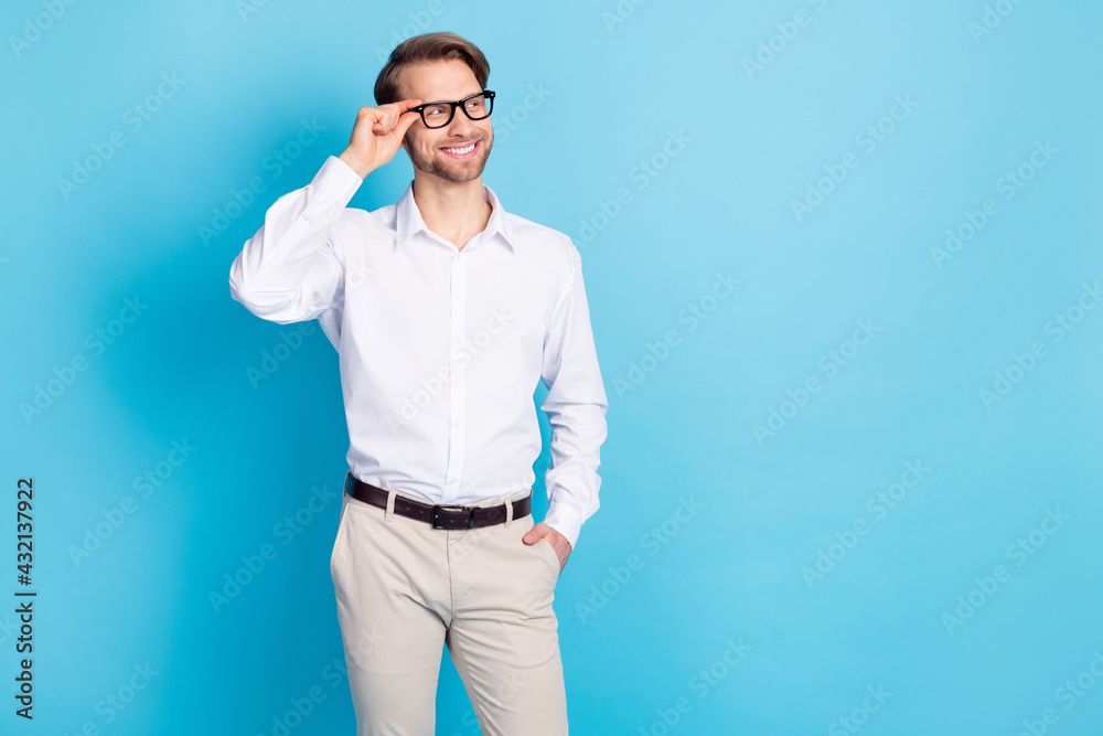 Portrait of attractive cheerful man leader touching specs looking aside copy space isolated over bright blue color background Portrait of attractive cheerful man leader touching specs looking aside copy space isolated over bright blue color background