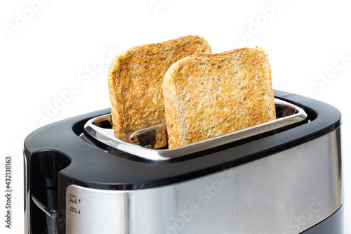 Brown fried toast in medium plan in toaster on white background