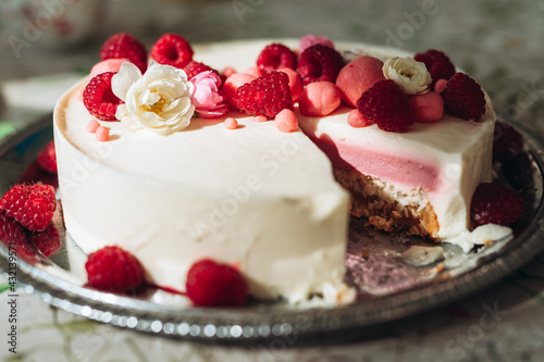 White cake with berries and flower on top photo