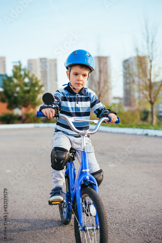 A child in a helmet and protection in a bike ride on nature in the spring © johnalexandr