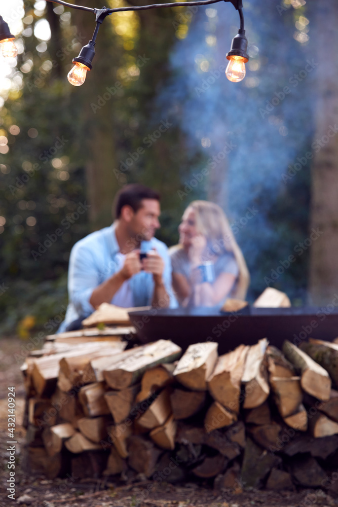Romantic Couple Camping Sitting By Bonfire In Fire Bowl With Hot Drinks Romantic Couple Camping Sitting By Bonfire In Fire Bowl With Hot Drinks