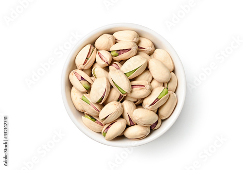 Flat lay of pistachio nuts in white bowl isolated on a white background.