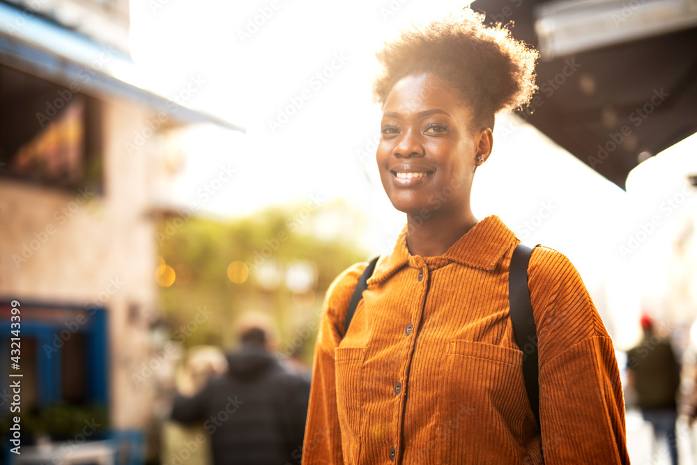 Fototapeta premium Young african woman enjoying outdoors. Beautiful woman with curly hair drinking coffee