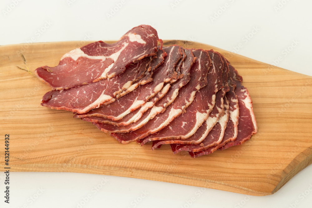 Sliced ​​fresh bacon on wood background.