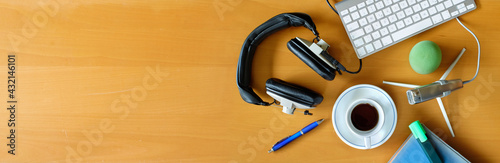 Recording podcast or audiobook concept, flat lay with headphones, vintage microphone, coffee and keyboard on wooden table, large free copy space, panoramic photo