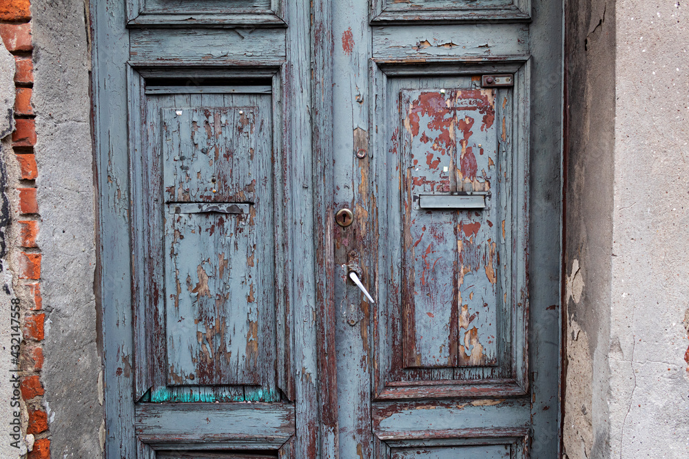 Old wood door in blue, textured embossed paint on wood