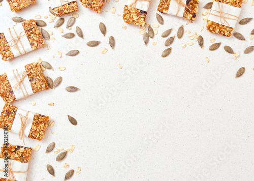 Granola bar and ingredients on a white stone table.Top view. Copy space.