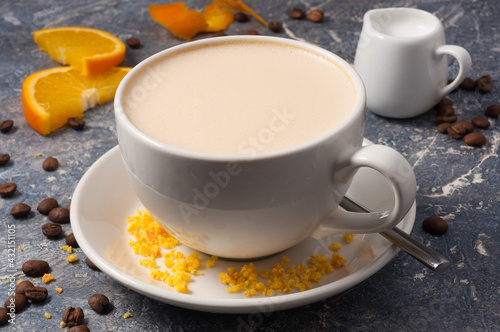 coffee with milk and oranges on a gray background