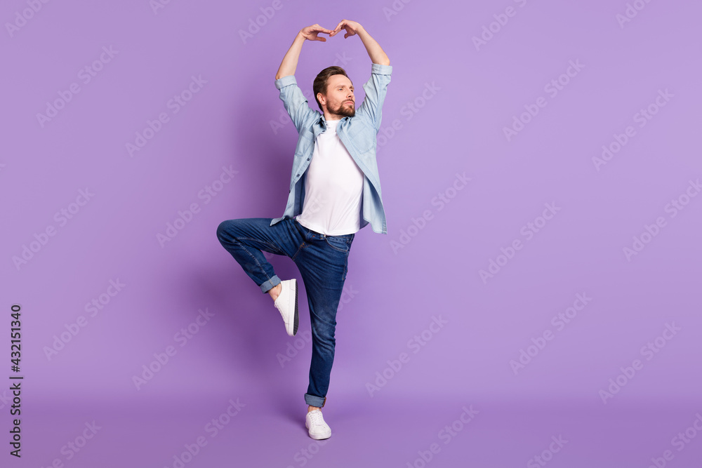 Photo of sweet handsome young guy dressed denim shirt dancing looking empty space isolated purple color background Photo of sweet handsome young guy dressed denim shirt dancing looking empty space isolated purple color background