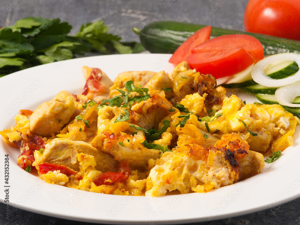 egg scramble with chicken decorated with greens on a white plate egg scramble with chicken decorated with greens on a white plate