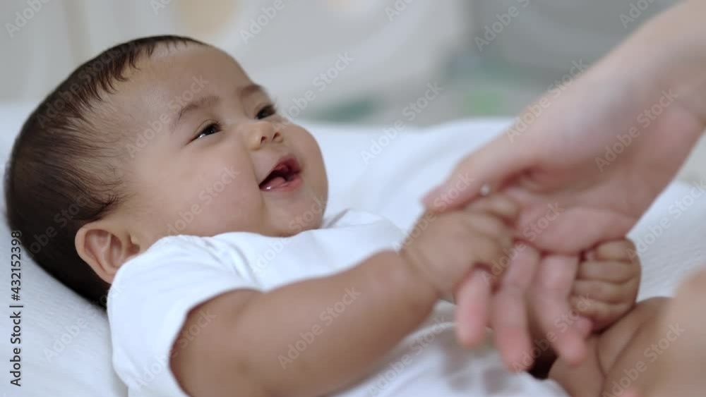 A cute baby wearing a white dress Stay with parents in the house Holding hands parents love family A cute baby wearing a white dress Stay with parents in the house Holding hands parents love family