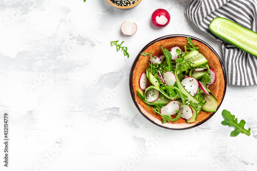 Green vegan salad from green leaves mix and vegetables. salad of radish, cucumbers, arugula. Healthy vegan food. place for text, top view © Надія Коваль