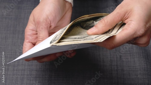 Female hands counting US dollars bills in white envelope. Saving money, family budget, crisis, shadow economy photo