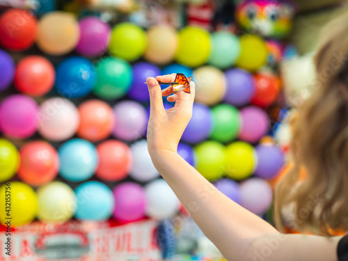 Mano sujetando un dardo en una tómbola de globos 